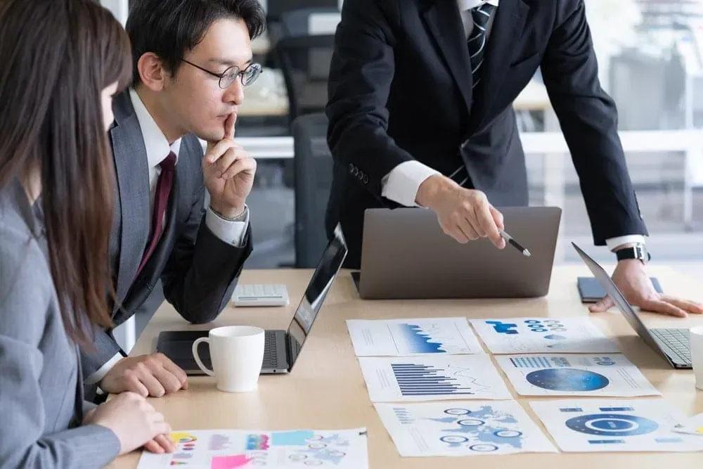 Business meeting with charts and laptops on table