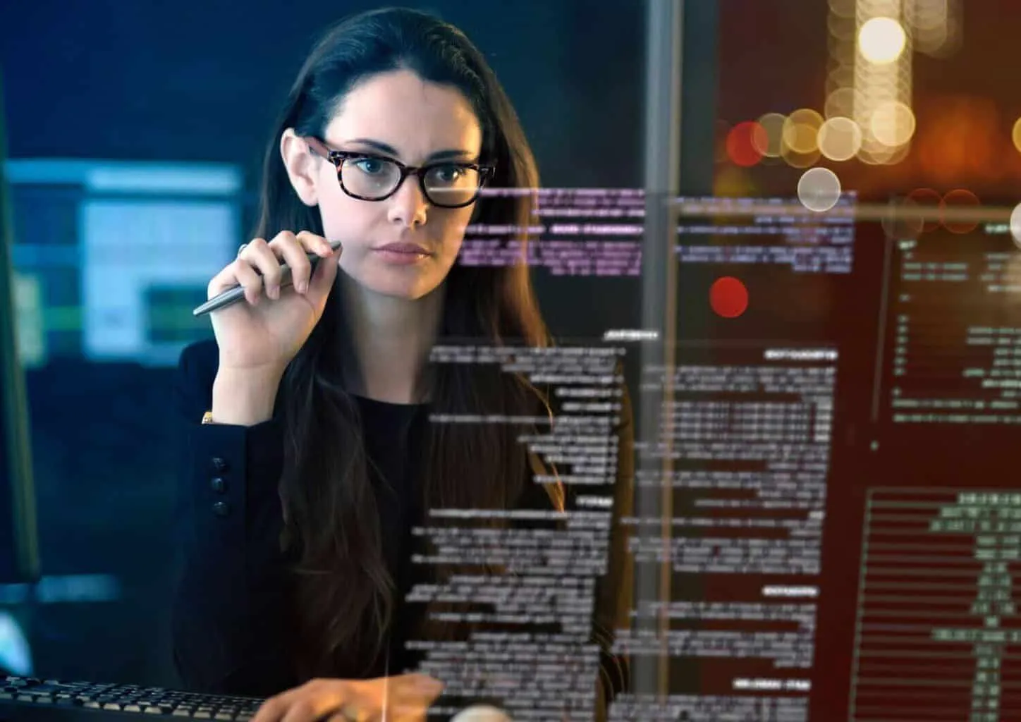 Woman analyzing code on computer screen