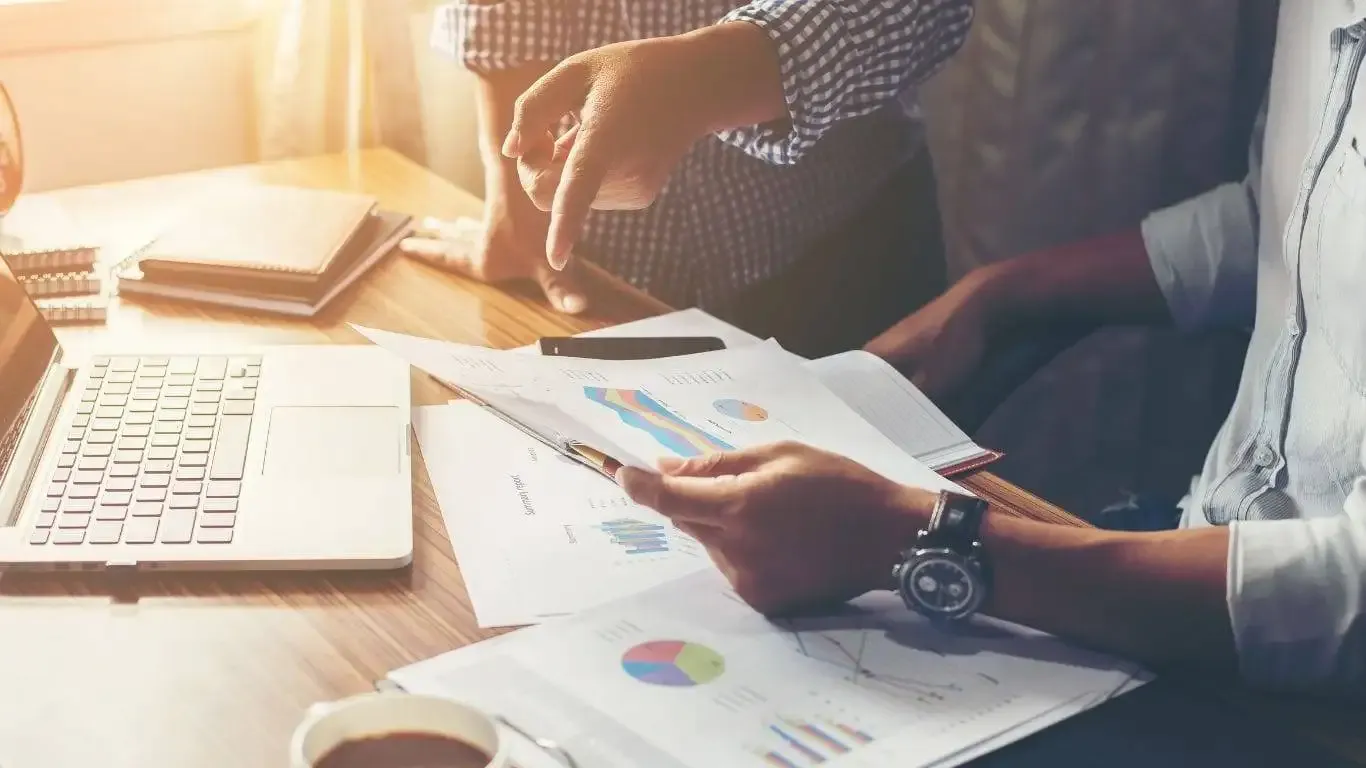 Colleagues discussing business reports and charts.