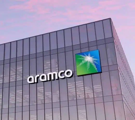 Aramco building with glass facade at sunset.