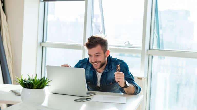 Happy man celebrating success on laptop