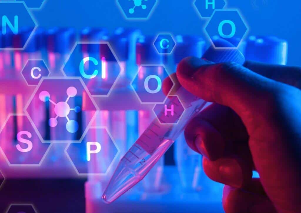 Hand holds test tube with chemical formulas overlay.