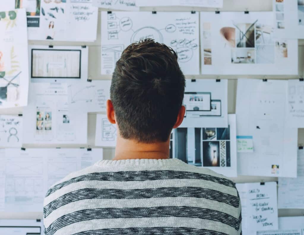 Person analyzing strategy on wall of papers