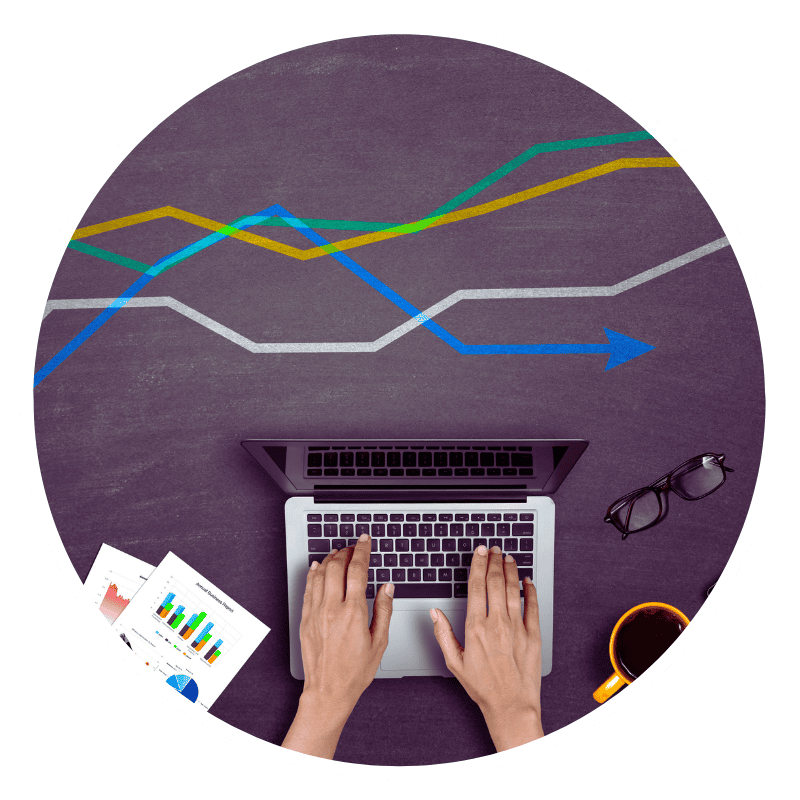 Person typing on laptop with business charts.