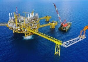 Offshore oil platform with crane and flare stack.