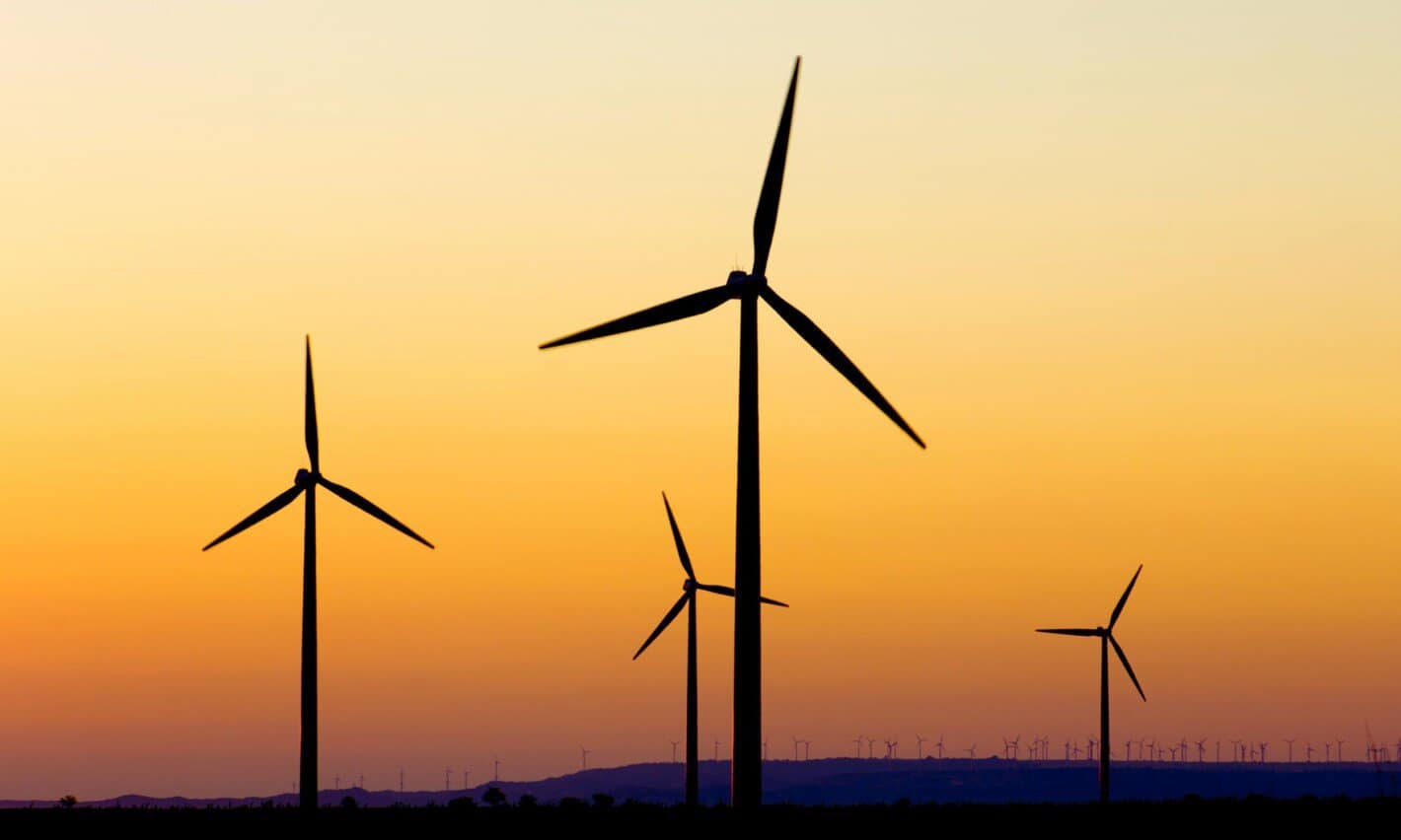 Wind turbines at sunset in a field